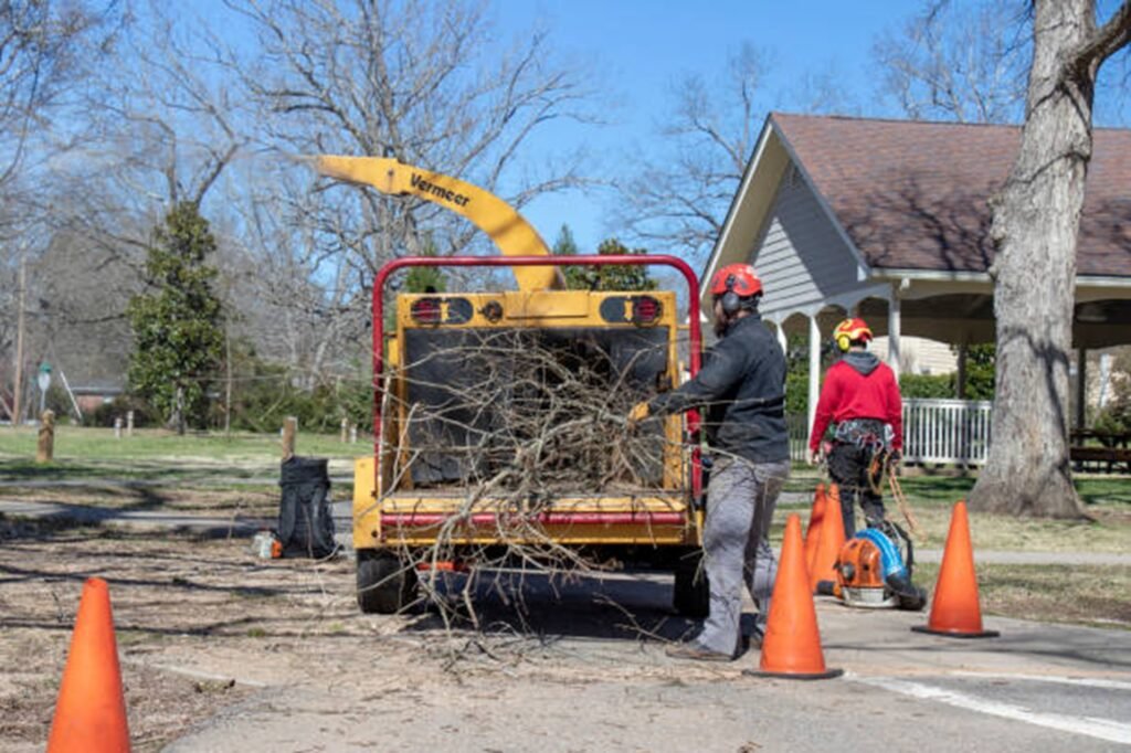 Riverbend Tree Service crew loading tree branches into a wood chipper after completing a residential tree service project in Eureka, MO.